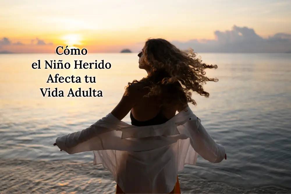 Mujer de espaldas con aspecto relajado cerca del mar, reflejando la introspección y la reconciliación con el niño interior en el proceso de sanar heridas emocionales que afectan la vida adulta