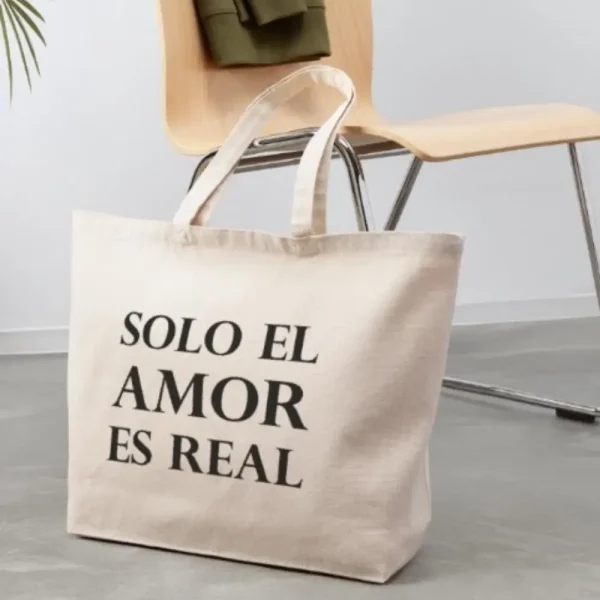 Bolso tote color beige con la frase en letras negras “Solo el amor es real”, artículo de merchandising de la Tienda Mente Uno disponible en Amazon, TeePublic y Spreadshirt