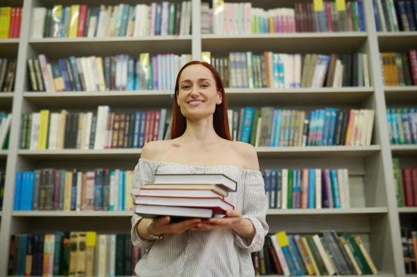 autora sosteniendo sus libros con las manos